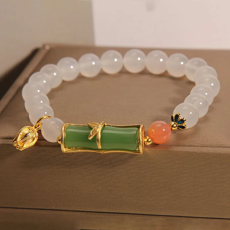 Close-up of a white agate jasper beaded bracelet with a jade bead in a Chinese bamboo style.
