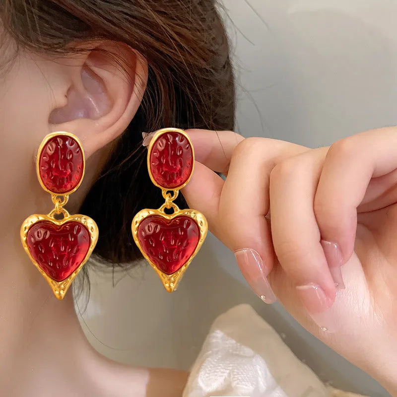 A pair of pleated oval love heart stud earrings in alloy, showing the silver needle post.