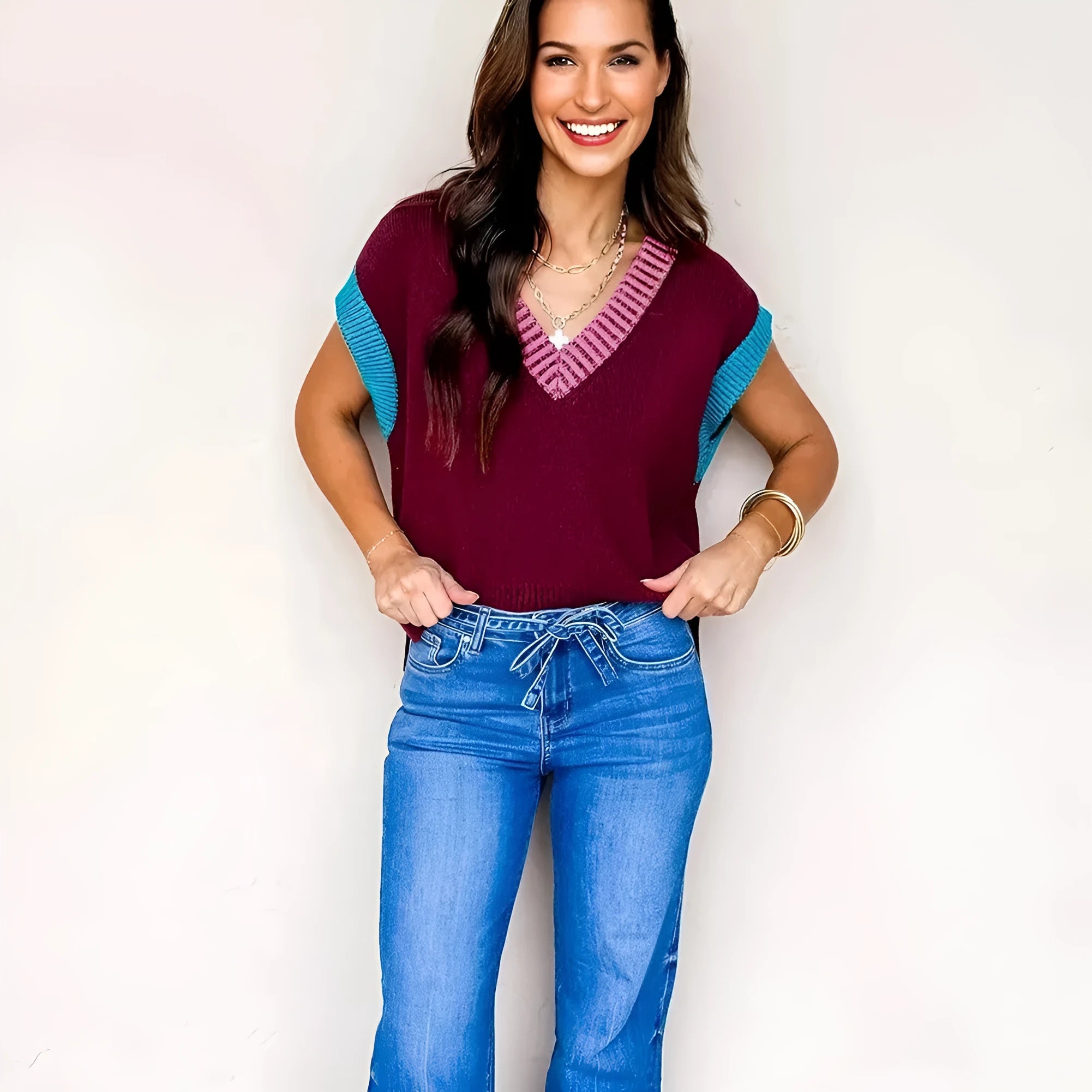 Burgundy loose sweater with V-neck, contrast trim, and cuffed short sleeves on a hanger.