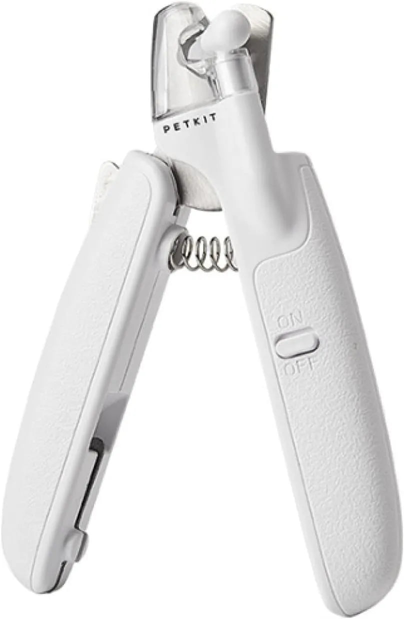 White pet nail clippers with LED light, anti-splash guard, and built-in file on a grey surface
