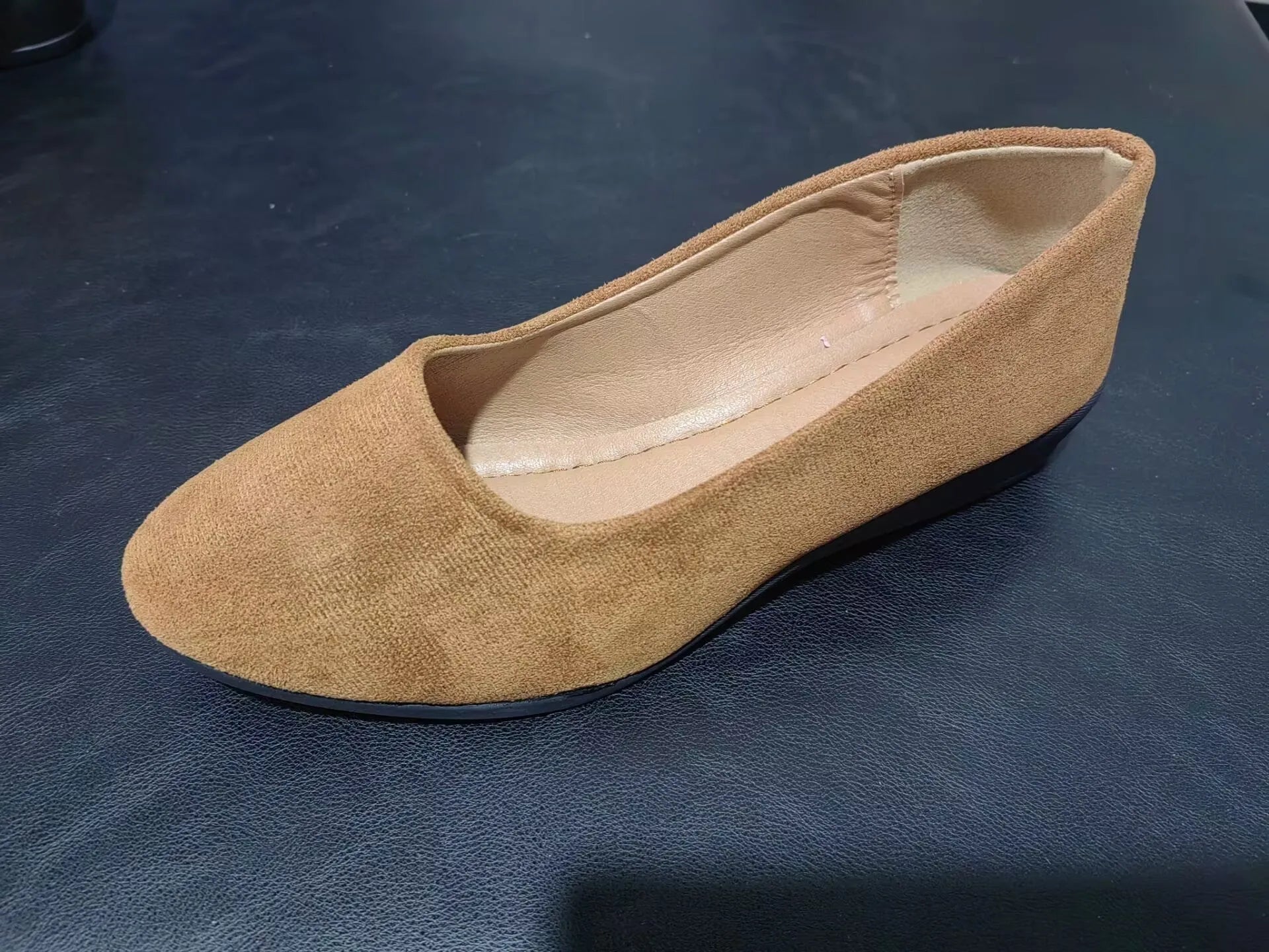 Women's suede wedge pumps in light brown colour showing shallow mouth design and low wedge heel