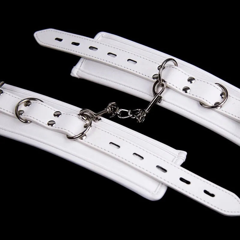 White PU sponge sex toy bondage kit showing handcuffs, foot cuffs, and a neck scarf arranged together.