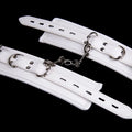 White PU sponge sex toy bondage kit showing handcuffs, foot cuffs, and a neck scarf arranged together.