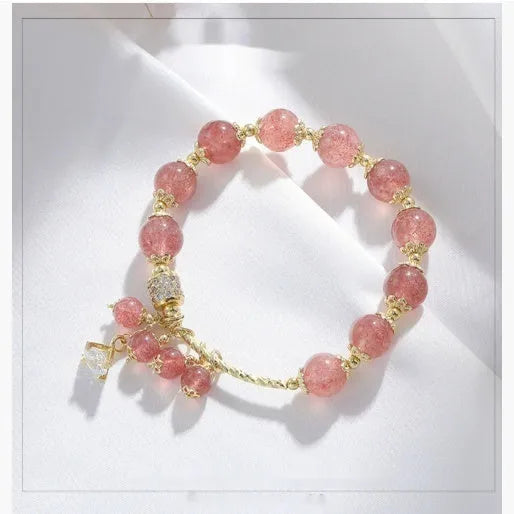 Women's pink strawberry quartz crystal bracelet with heart-shaped charms and pearl decorative elements
