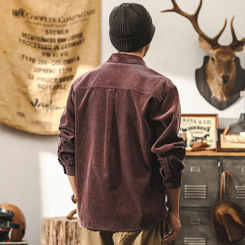Man wearing a loose-fit red corduroy long-sleeved shirt jacket.