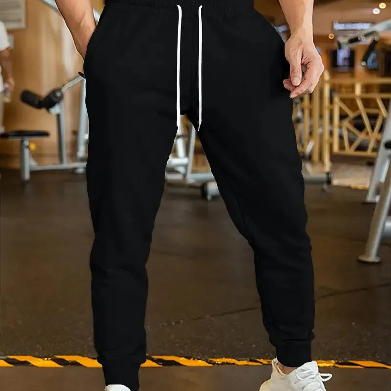Men's loose-fit casual trousers with an elastic drawstring waist in a neutral colour.