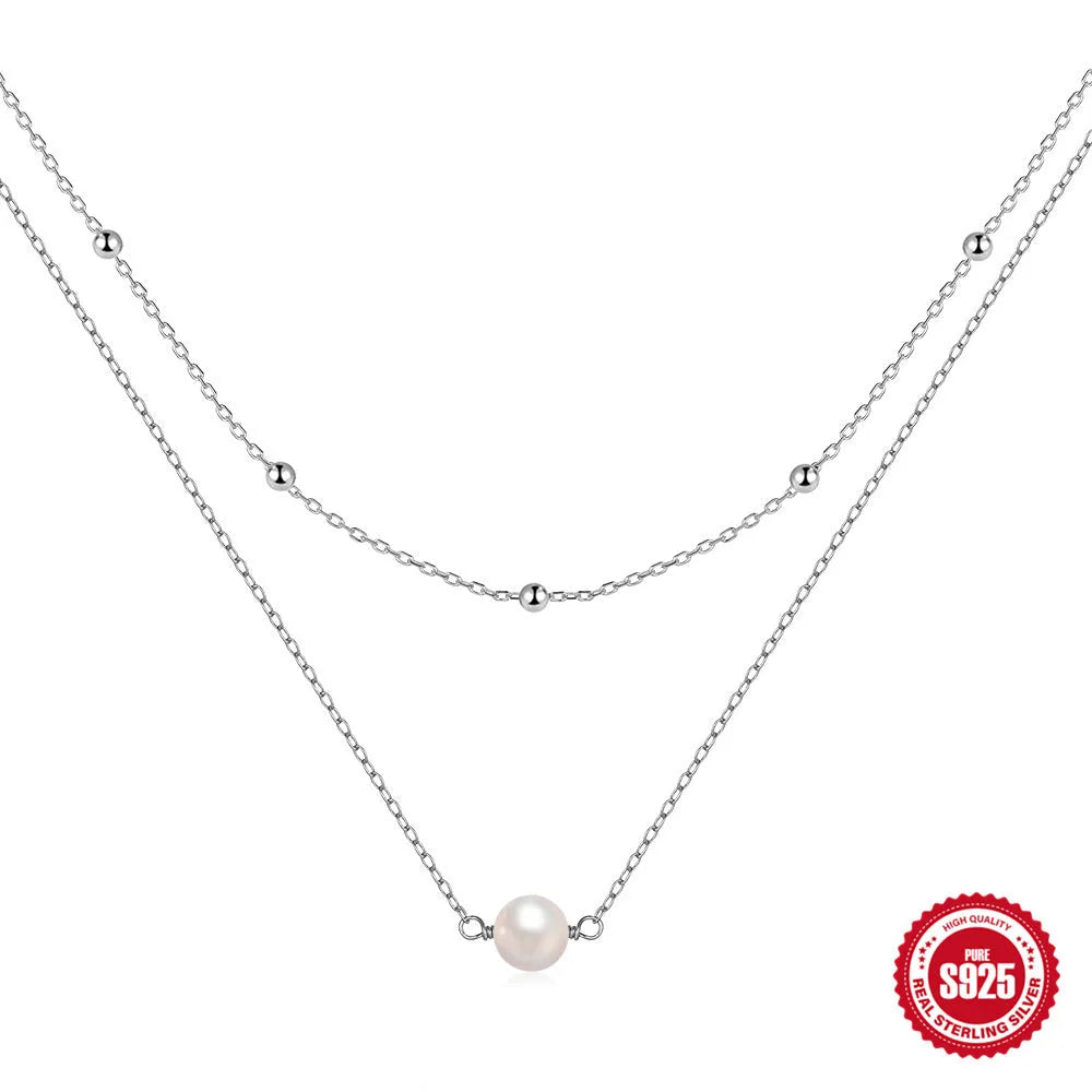 S925 sterling silver double layer necklace with twin pearls on a geometric pendant, shown in gold and white gold finishes.