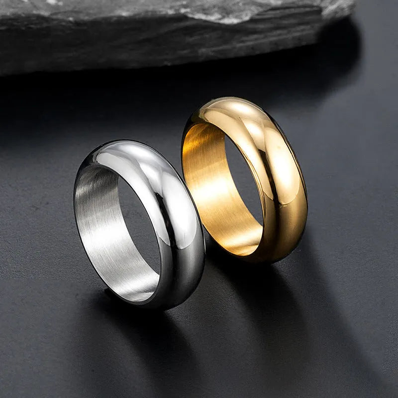 Glossy electroplated titanium steel ring in gold colour on a grey background.
