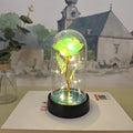 Small decorative night lamp with coloured plastic flower cover and black base on a table.
