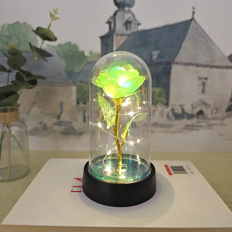 Small decorative night lamp with coloured plastic flower cover and black base on a table.