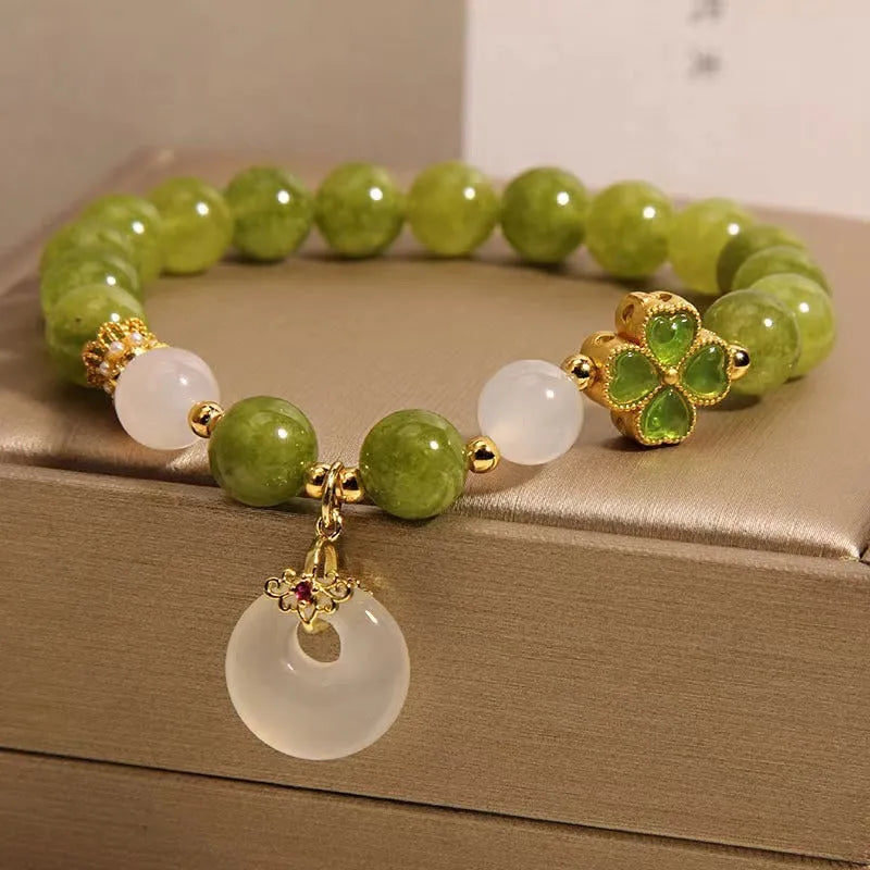 Green tourmaline four-leaf clover women's bracelet with safety buckle clasp on a white background.