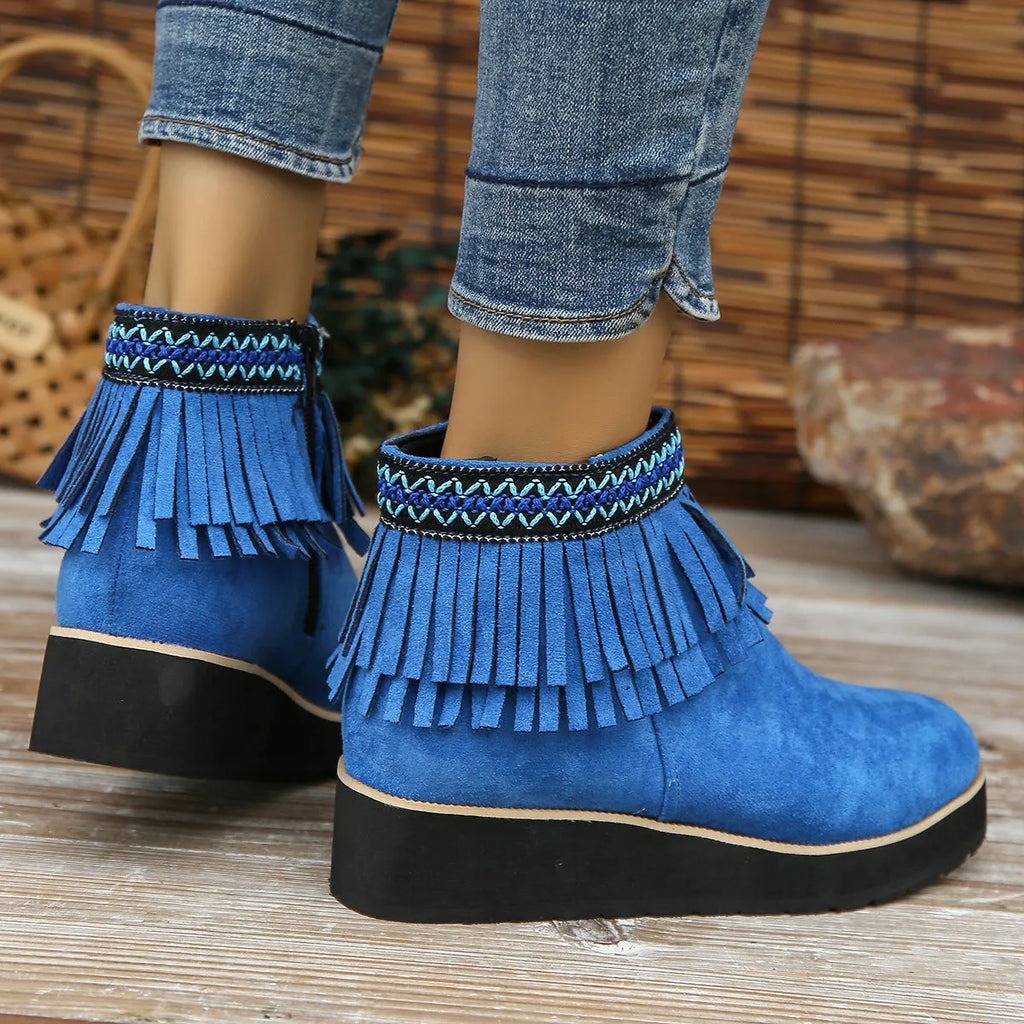 Women's suede ankle boot with wedge heel, side zipper, and tassel detail in dark brown.