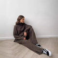 Women's dark grey side-slit sweater and trousers suit set on a hanger