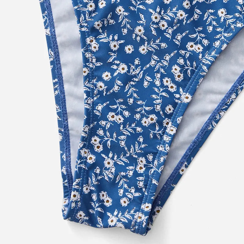 Blue women's three-piece swimsuit set with top and shorts on a white background.