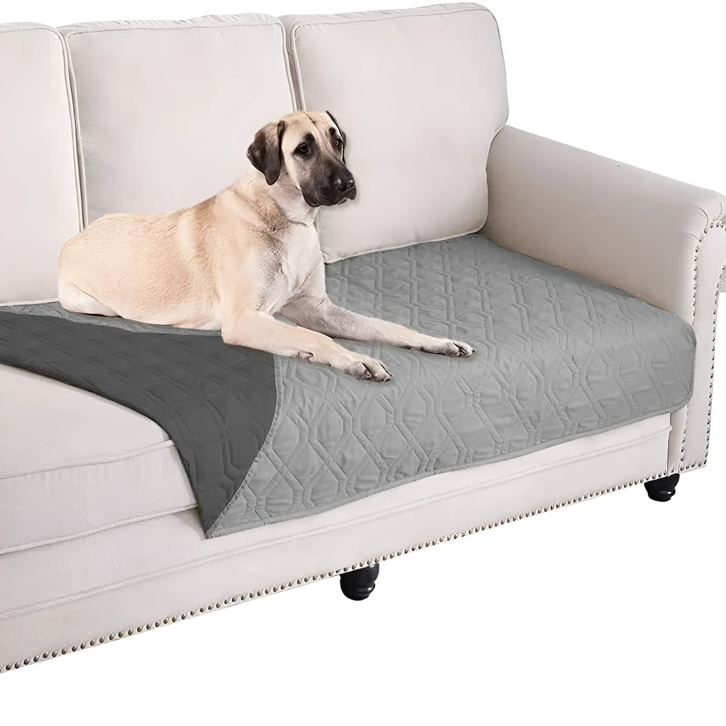 Reversible waterproof dog blanket laid flat on a sofa, showing two colour options.