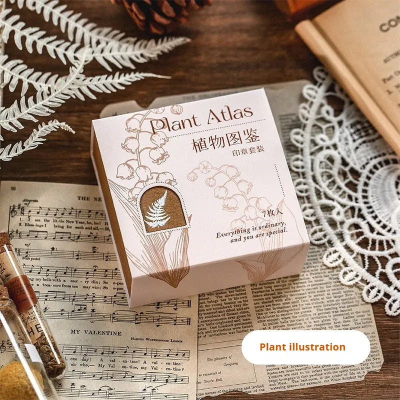 Set of seven wooden craft stamps for DIY journal decoration in stars and moon or plant catalog designs.