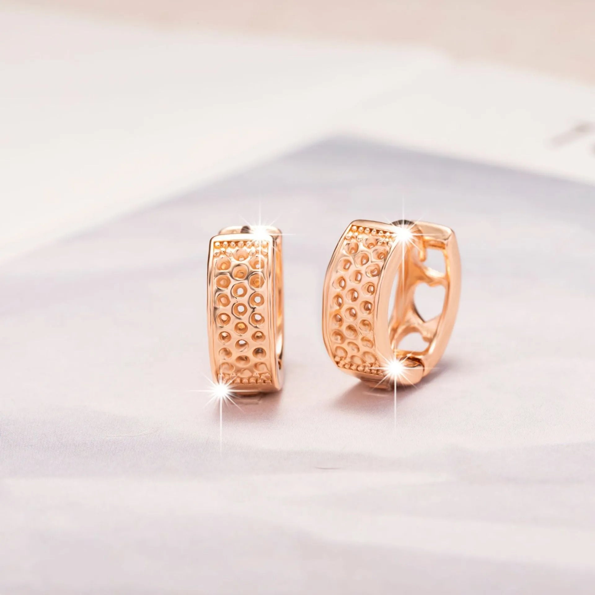 Rose gold electroplated earrings with three hollow heart shapes in circular arrangement