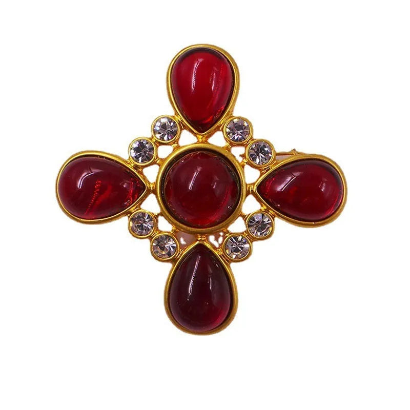 Close-up of vintage medieval baroque cross brooch with crystal details on zinc alloy base