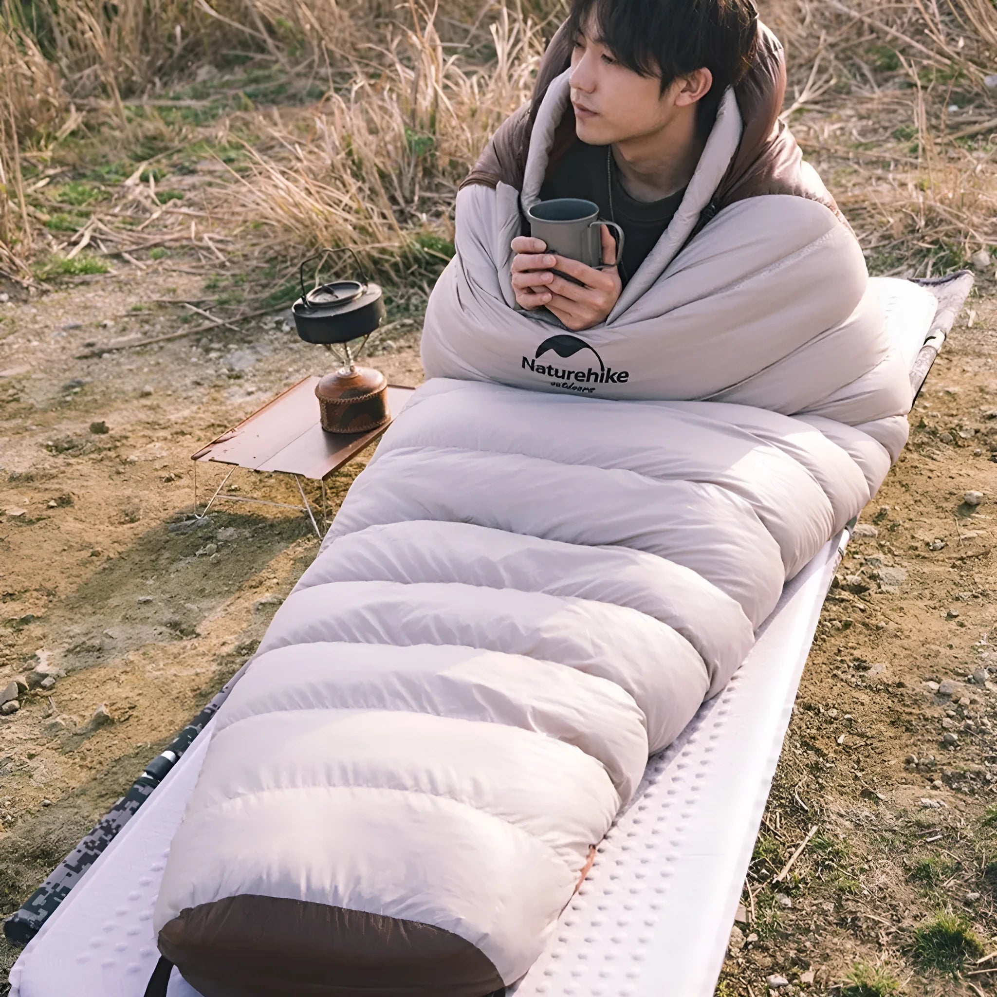 Adult mummy-style sleeping bag with goose down insulation shown with its storage bag.