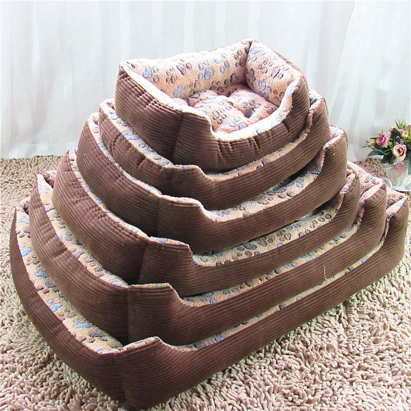 Beige plush sofa-style pet bed for small dogs with a raised bolster edge, shown in a home setting.