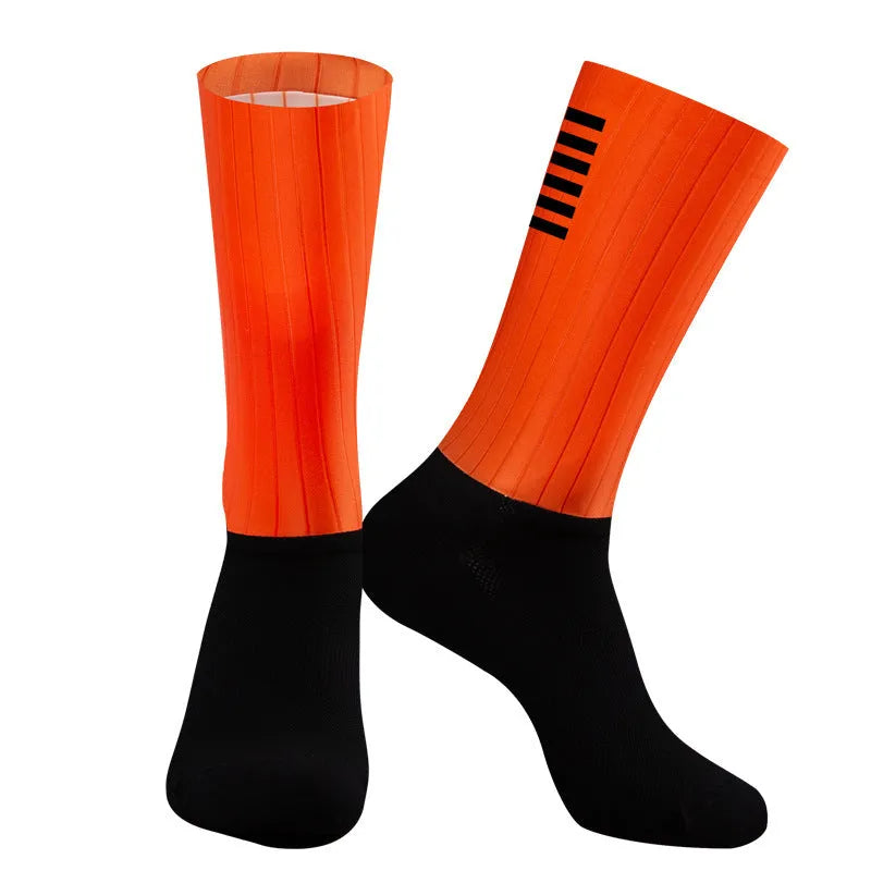 Pair of breathable athletic socks for running and cycling in orange colour on a grey background
