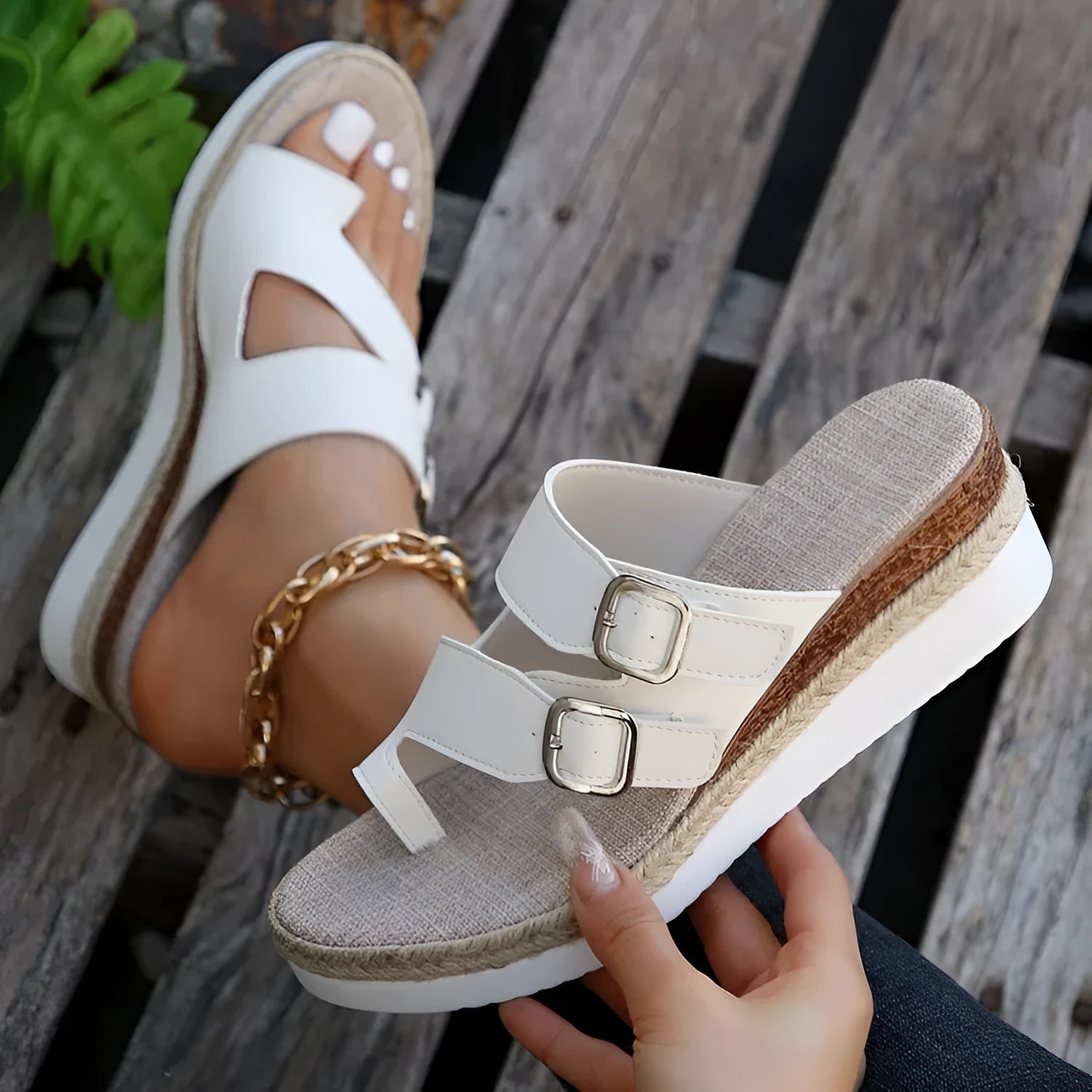White wedge heel sandals with woven patent leather upper and peep toe design on neutral background