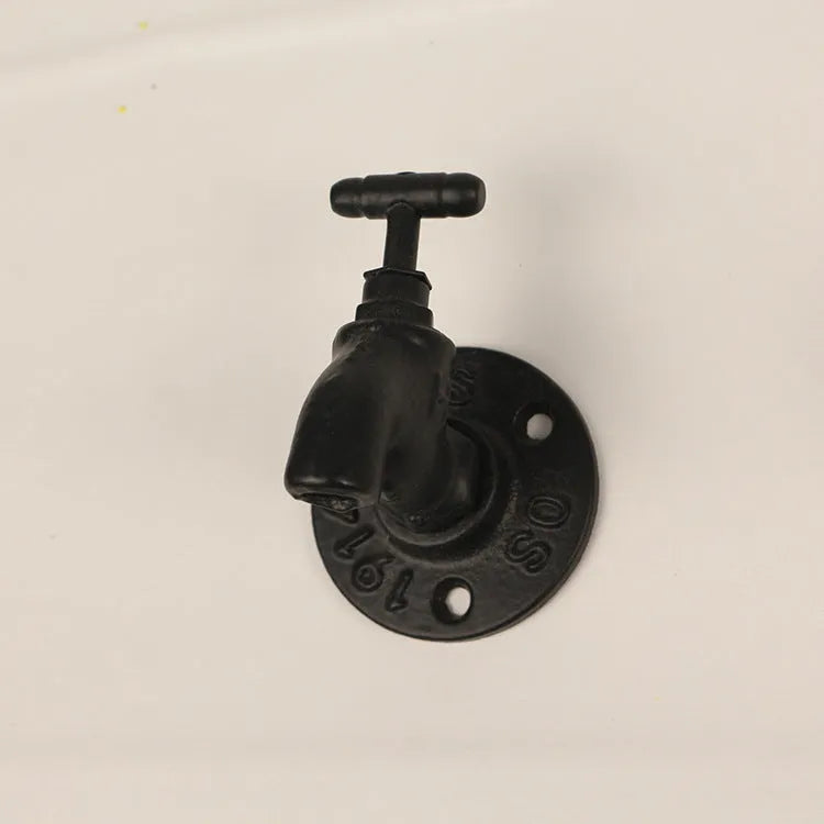 A polished metal wall hook in a water pipe design, shown in black, green, and red colour options.