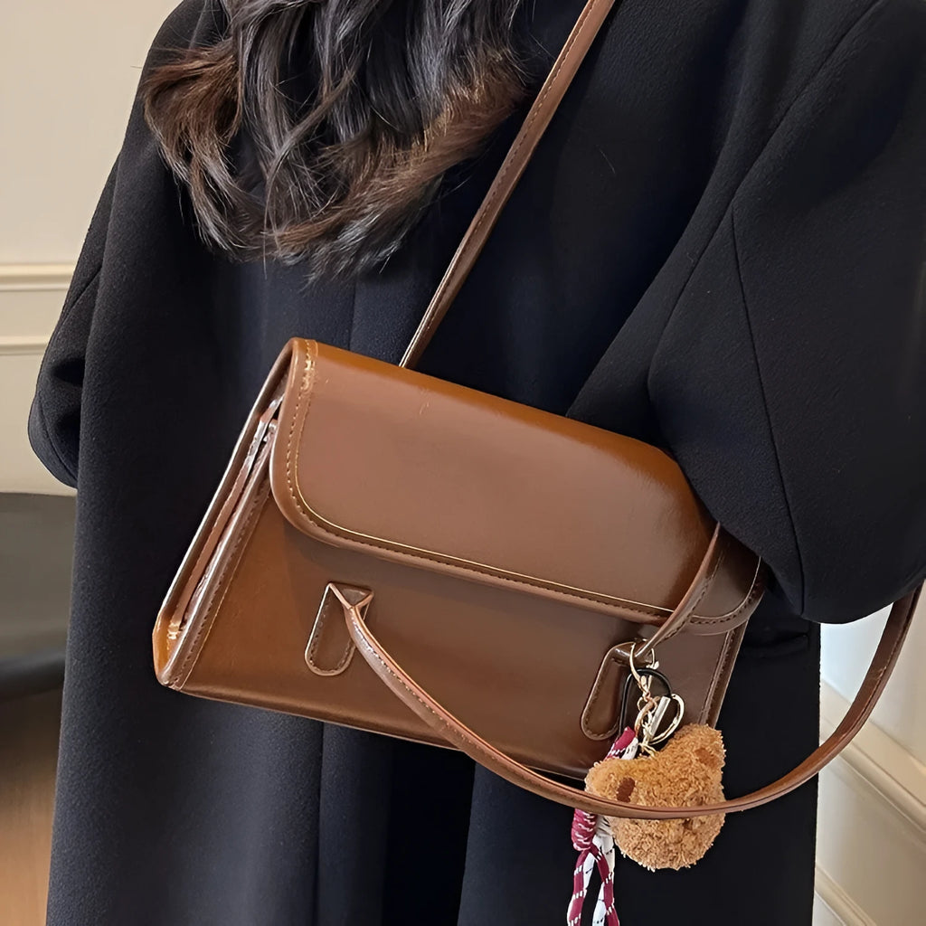 Women's brown PU leather shoulder bag with square shape, double straps, and decorative pendant attachment