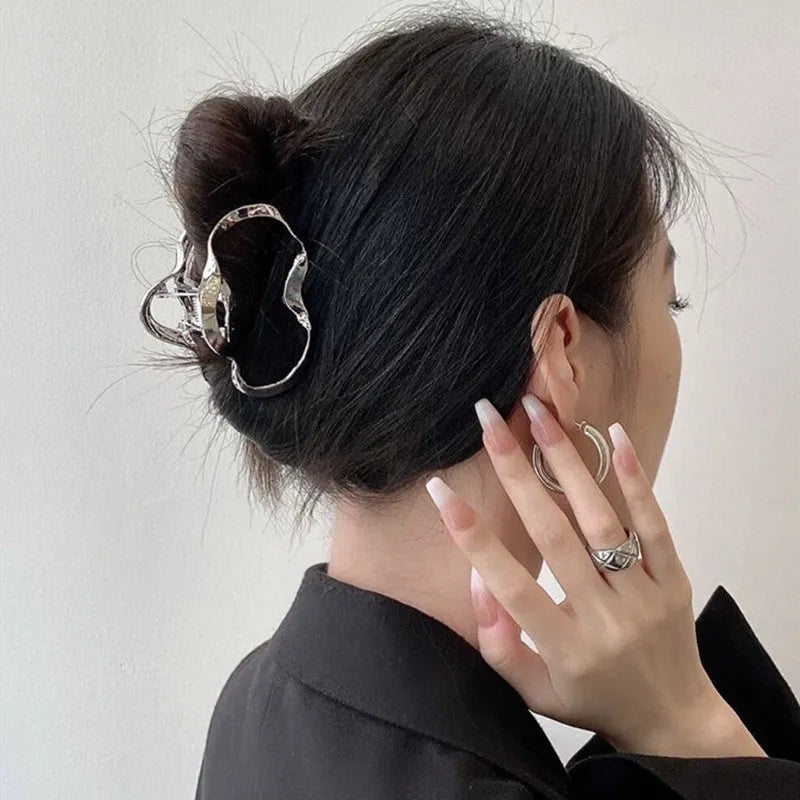Silver metal hair claw clip assortment showing bows, waves, pearl designs, and geometric shapes from 4cm to 13.5cm