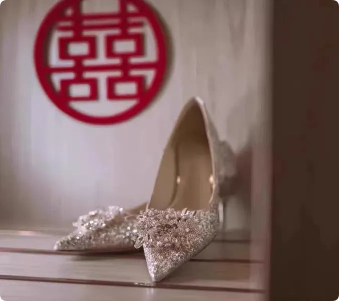 Champagne coloured bridal shoes with pointed toe, fine heel, and rhinestone floral decoration.