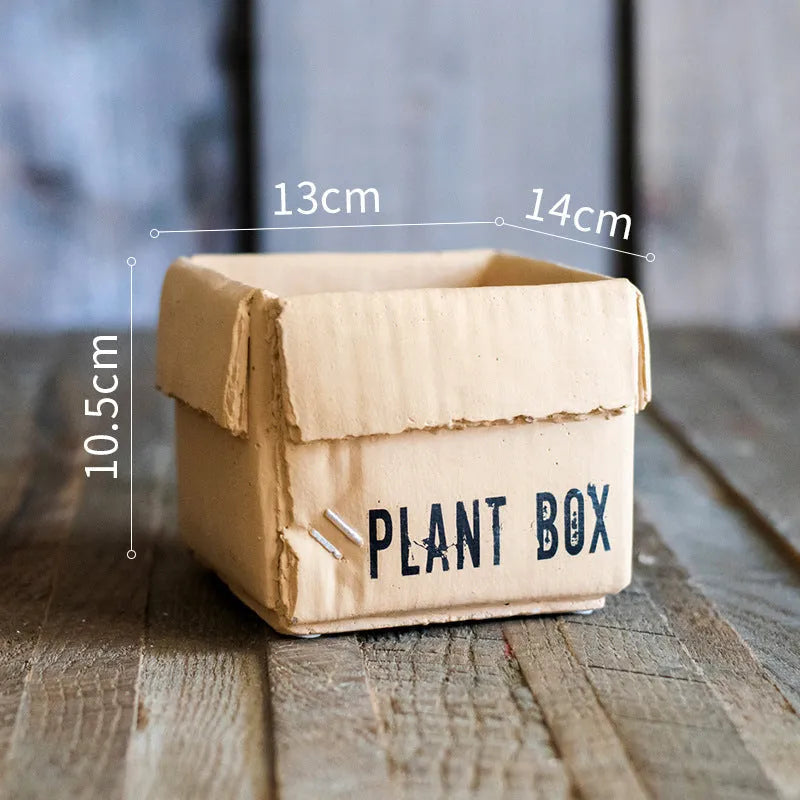 Cement flowerpot styled as a brown paper box with drainage hole for indoor balcony gardening
