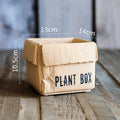 Cement flowerpot styled as a brown paper box with drainage hole for indoor balcony gardening
