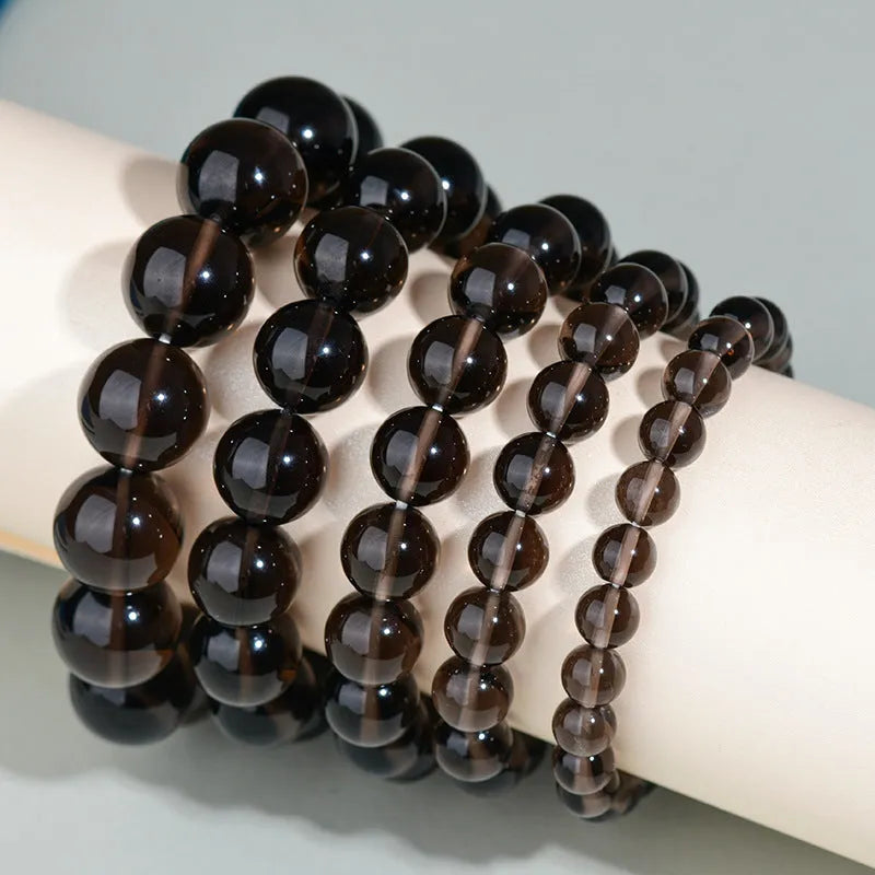 Hand-woven round obsidian bead bracelet in multiple colour options on a wrist.