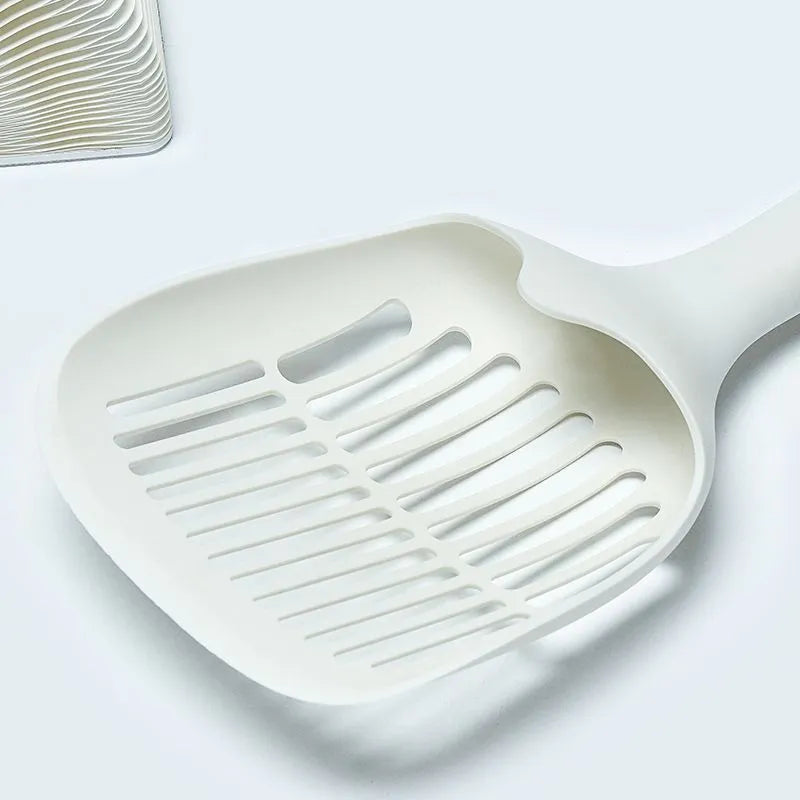 White plastic cat litter scoop with storage base on a clean surface