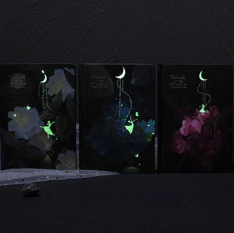 A5 notebook with a luminous cover in one of four colours, open to show pages with colour illustrations