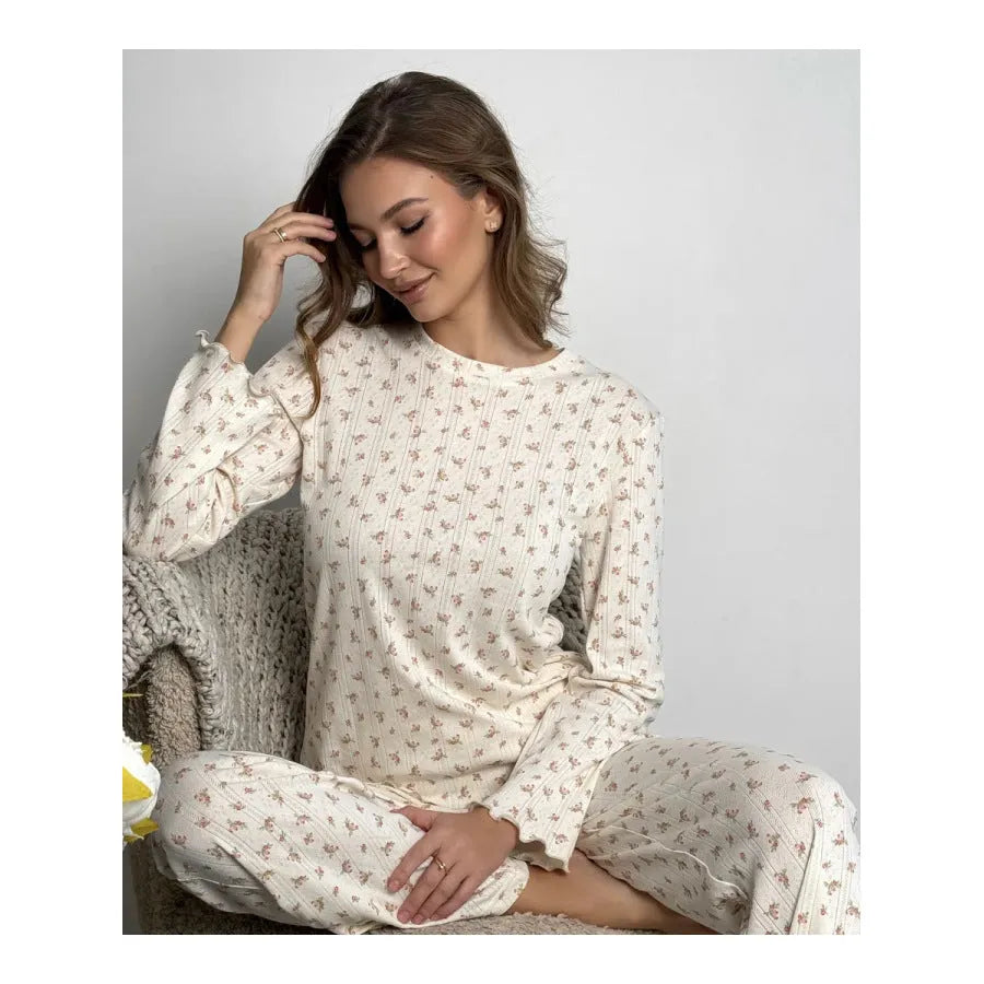 White women's floral print two-piece suit with bell sleeve top and wide-leg trousers on a hanger.