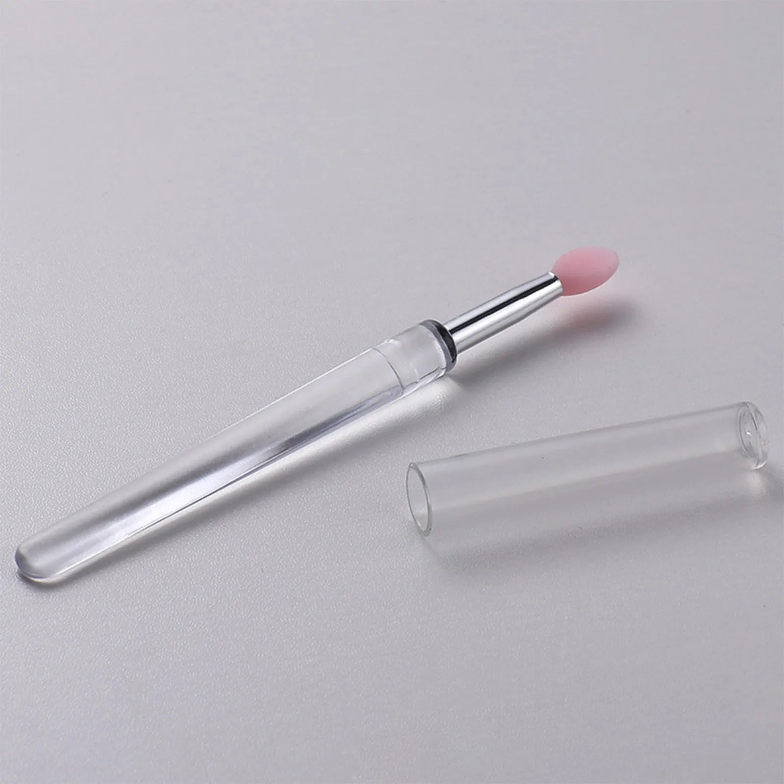 A reusable silicone lip brush with a handle and protective cap, shown in one of eight available colours.