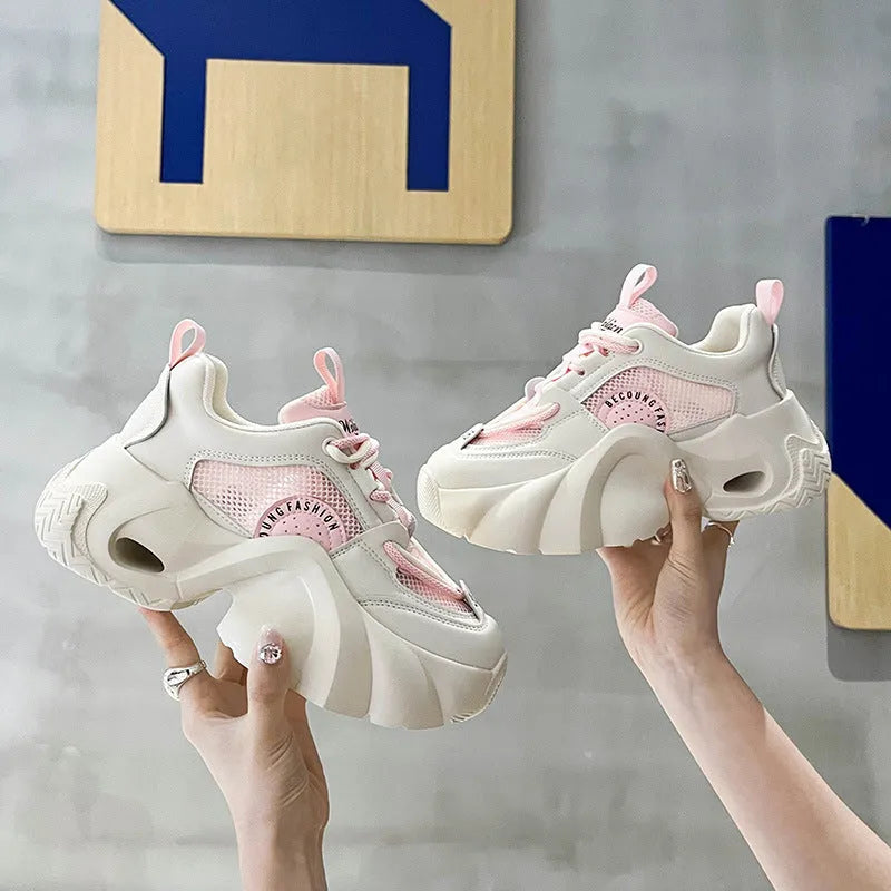 Women's pink casual sneakers with cross strap design and thick sole showing side profile
