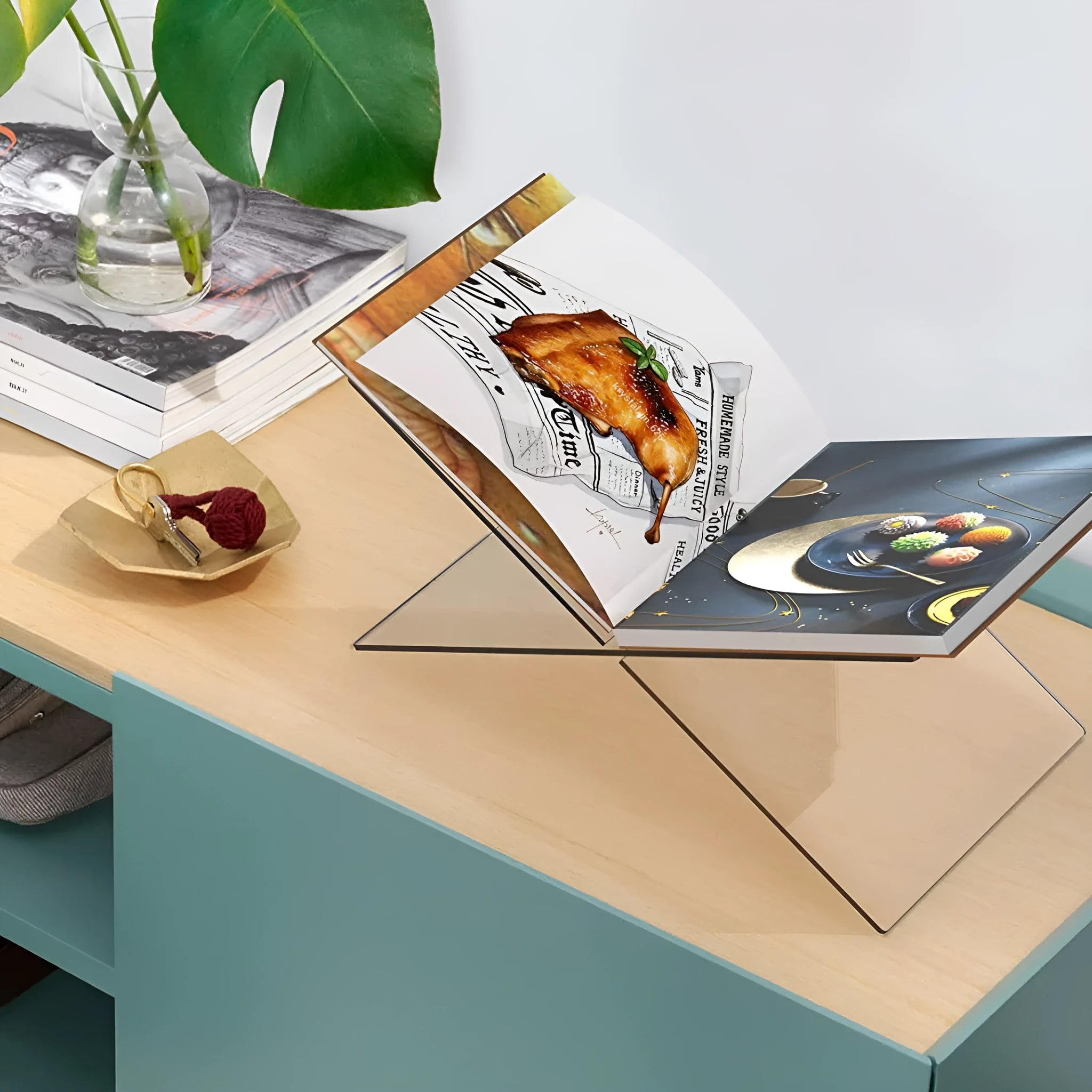 Clear acrylic X-shaped book display rack holding books upright on desktop
