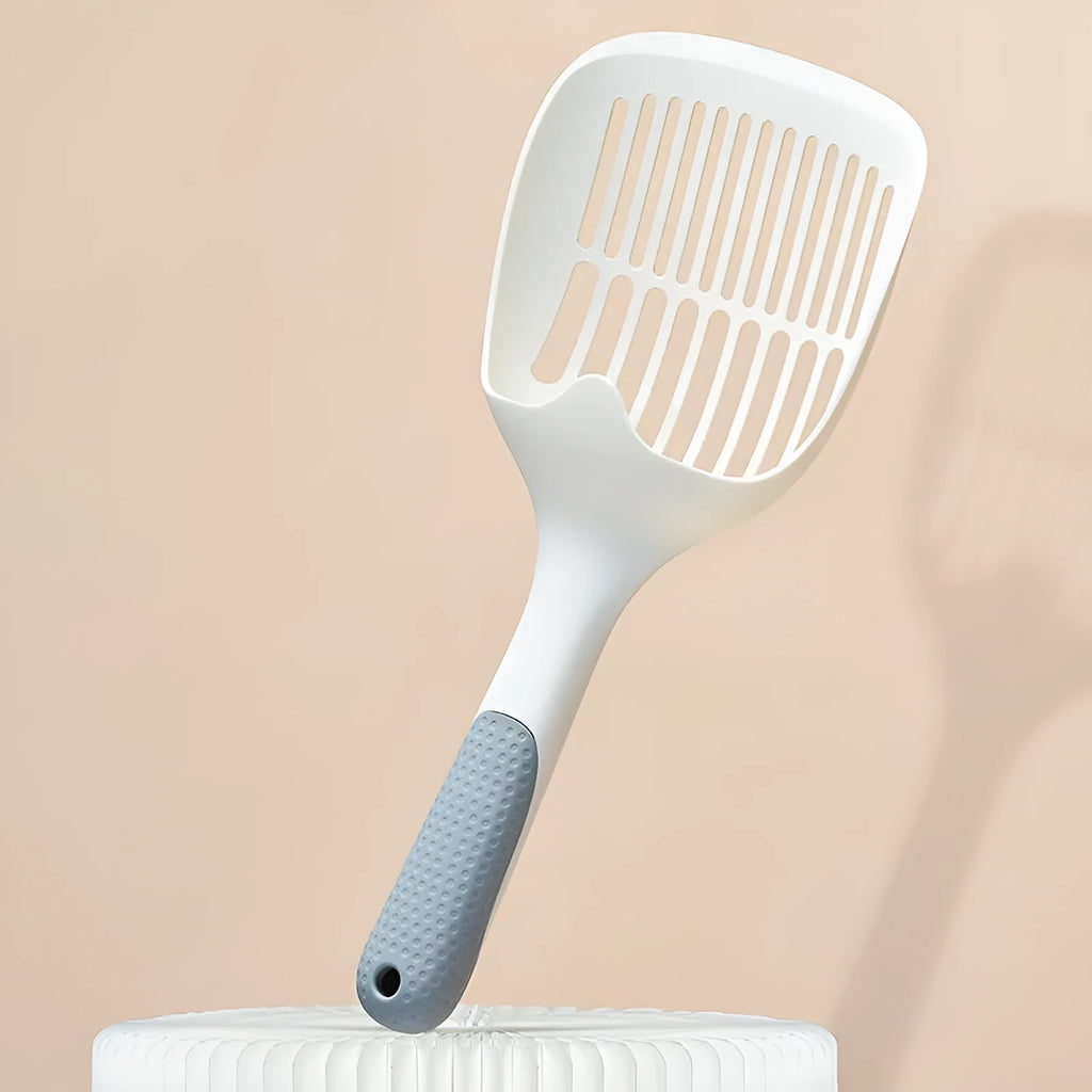 White plastic cat litter scoop with storage base on a clean surface