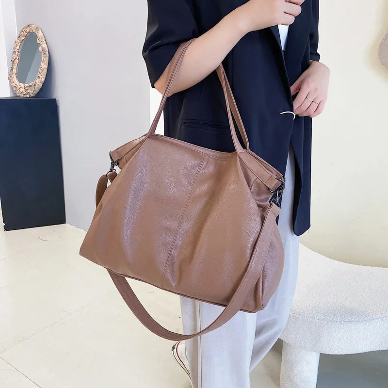 Large soft surface black messenger bag with a shoulder strap and zipper opening.