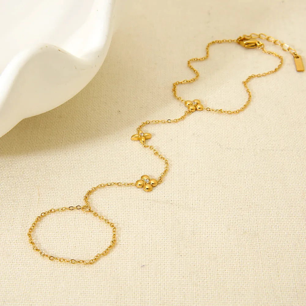 Gold stainless steel women's bracelet with floral and eight-pointed star geometric design.