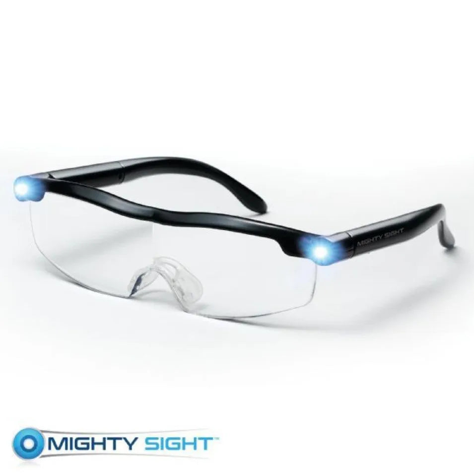 Transparent black USB LED reading glasses with integrated lighting, shown on reading material
