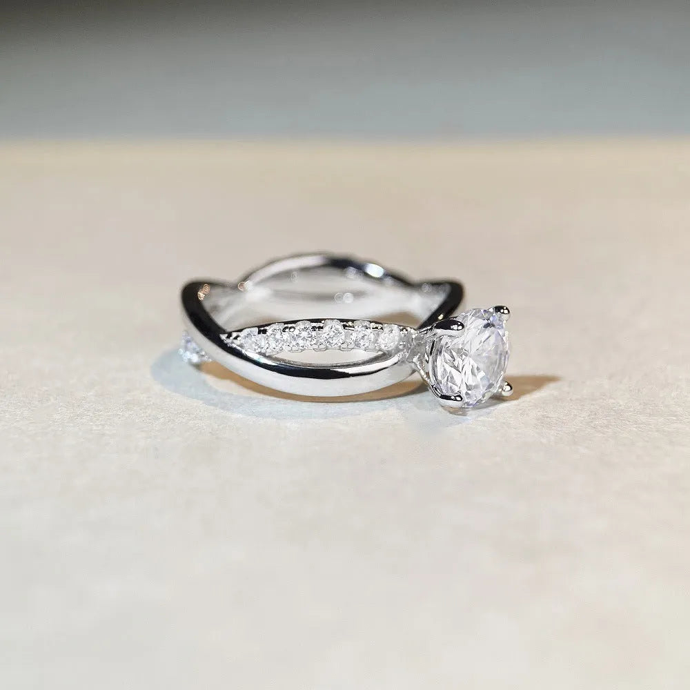 Geometric cross moissanite ring with winding twisted silver arms and four-claw setting