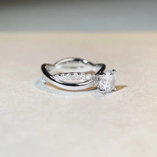 Geometric cross moissanite ring with winding twisted silver arms and four-claw setting