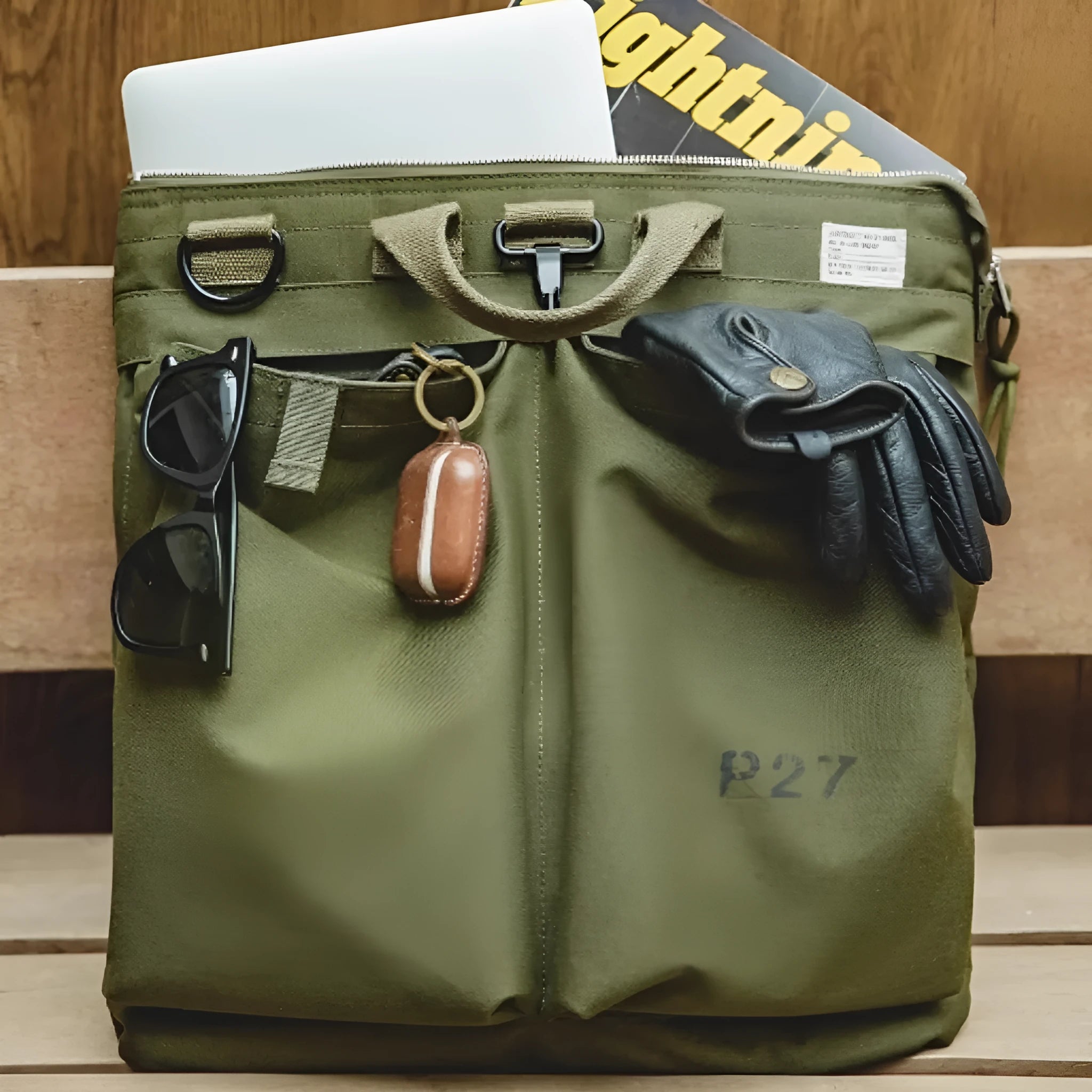 Canvas crossbody messenger bag in military green with shoulder strap showing vertical square shape and zipper closure