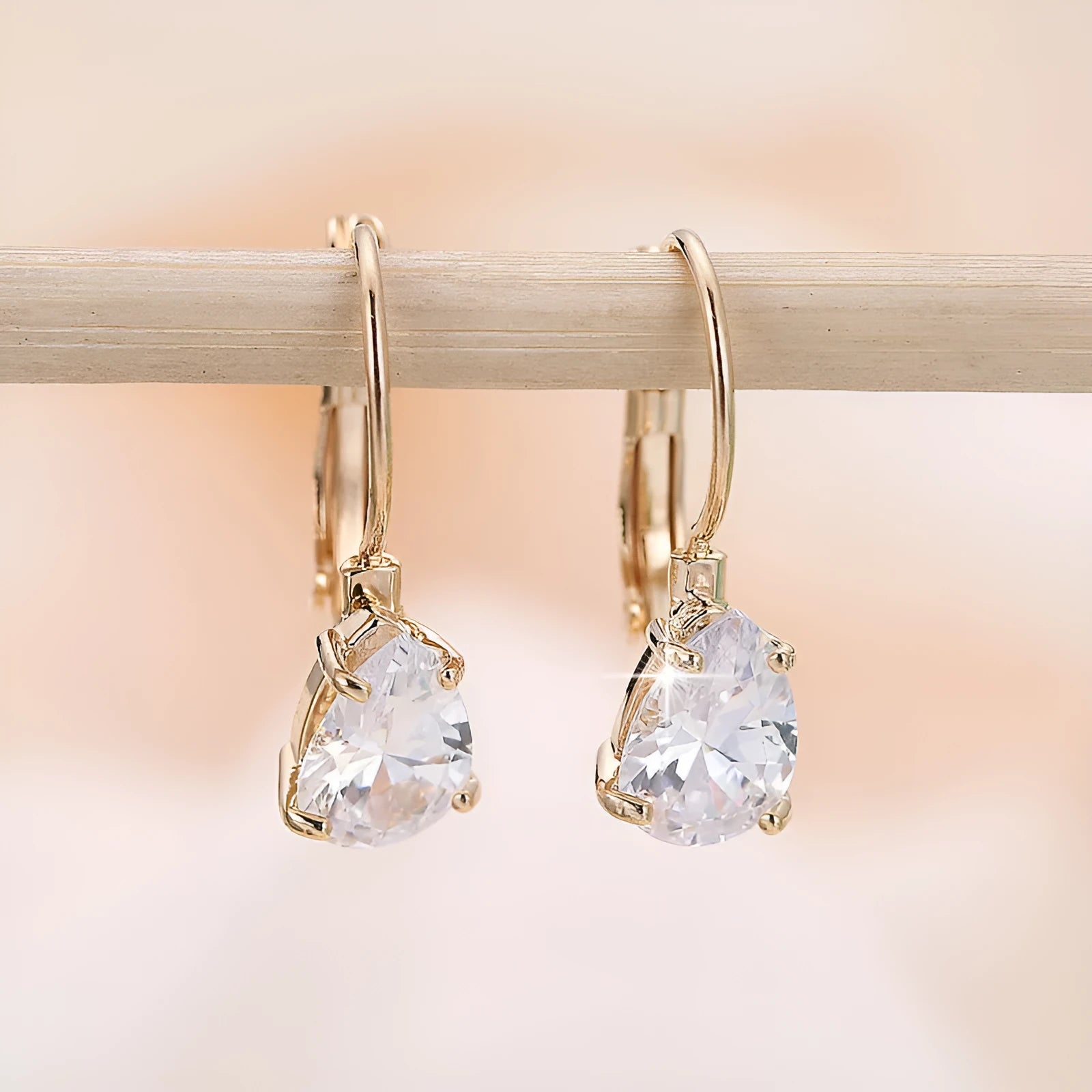 Drop-shaped metal earrings with platinum gem details in gold or platinum colour options