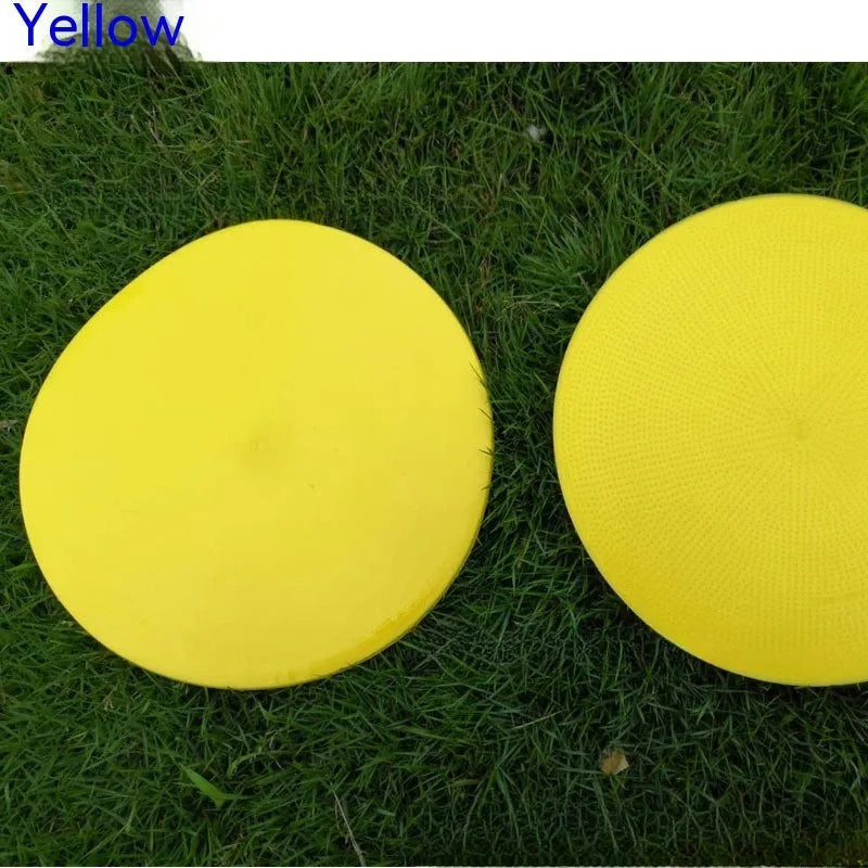 Flat, round yellow football training target disc with 23cm diameter on grass.