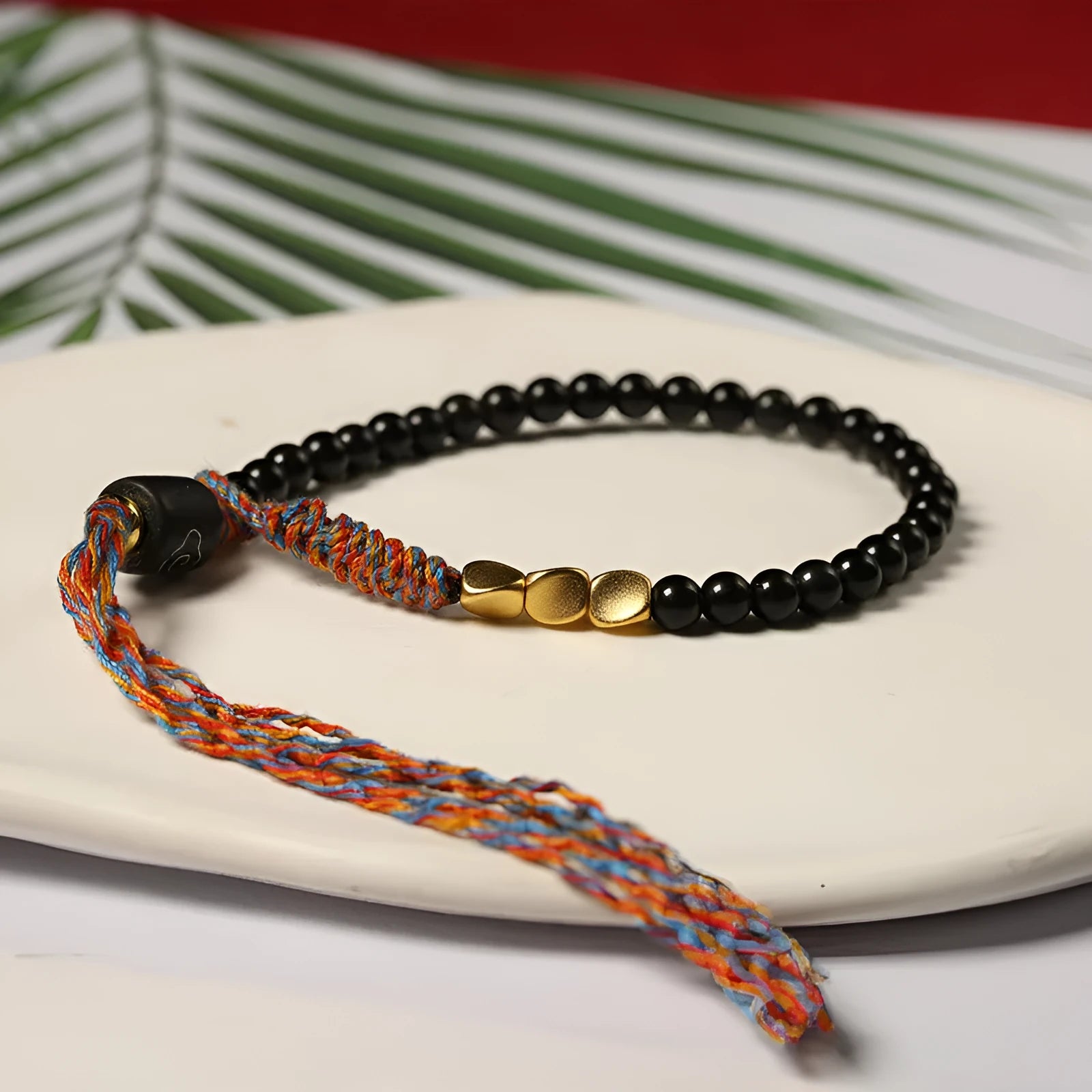 Hand-woven obsidian carrying strap bracelet showing textured weave and adjustable length