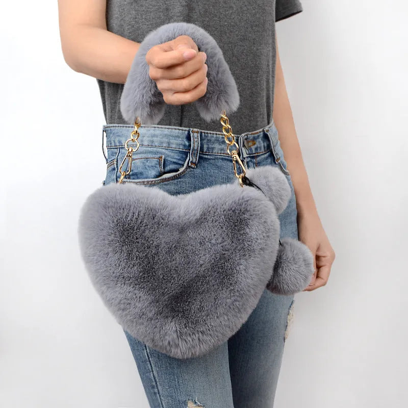 A soft plush heart-shaped women's handbag with a zipper and a detachable shoulder strap in a choice of 14 colours.